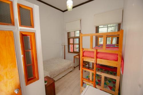 瓦尔帕莱索Hospedaje y Espacio Cultural La Casa Del Puerto, Cerro Alegre的客房设有两张双层床和一张床。