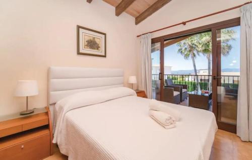 Sa TorreVilla La Mallorquina的一间带白色床的卧室和一个阳台