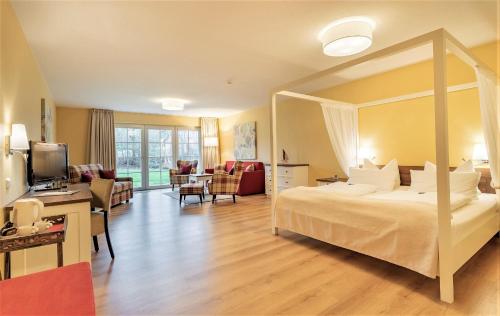 圣彼得奥尔丁Hotel Landhaus Ellerbrock的酒店客房设有一张大床和一间客厅。