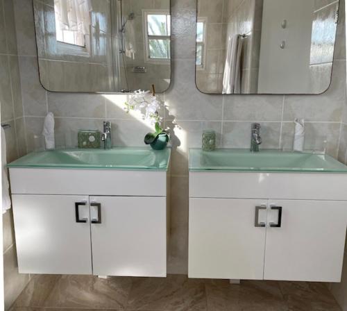 棕榈滩Beachside Villa at Boca Catalina的浴室设有2个水槽和镜子