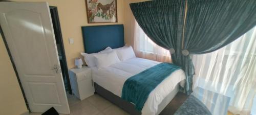 约翰内斯堡Zwelibanzi Guesthouse的一间卧室配有一张蓝色天蓬床