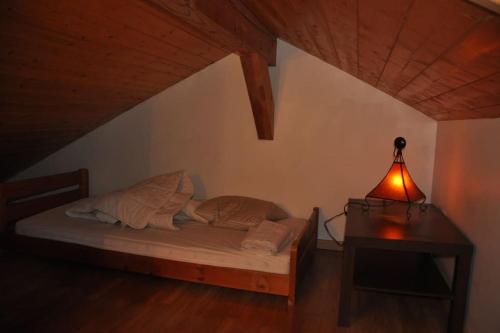 La PirrazAppartement en duplex dans chalet à Talloires的一间卧室配有一张带台灯和桌子的床