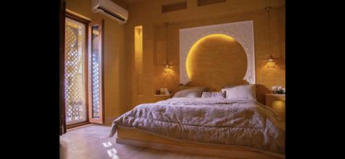 Al Khabrāʼشاليه غرناطة的一间卧室设有一张床和一个大窗户