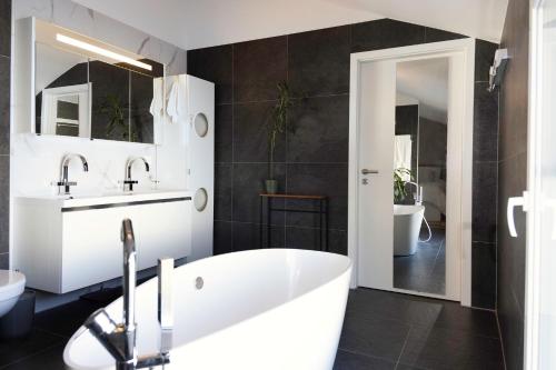 TreyvauxChambre Lumineuse Dans Une Maison Moderne的浴室配有白色浴缸和水槽