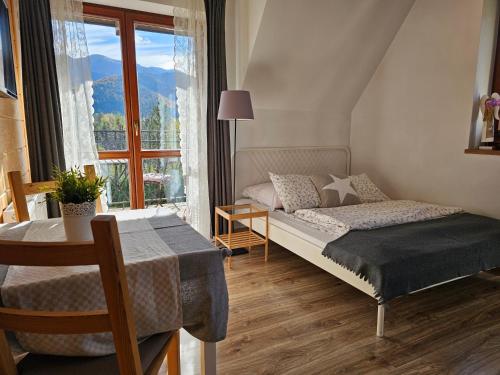 扎科帕内Panorama Szymaszkowa的一间卧室配有一张床、一张桌子和一个窗户。