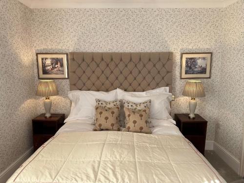 伯福德Burford Lodge Hotel - Adults only的一间卧室配有一张带两盏灯的大型白色床。