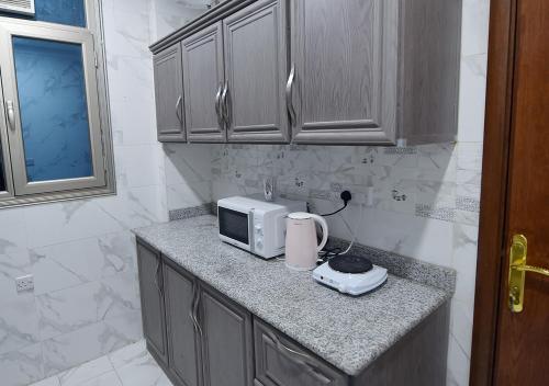科威特الدانة للشقق الفندقية的厨房柜台配有微波炉和烤面包机。