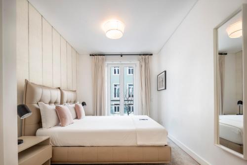 里斯本Marques Best Apartments | Lisbon Best Apartments的白色卧室设有一张大床和镜子