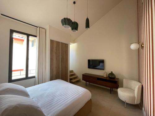 勒格罗-迪鲁瓦Villa Chiesa的一间卧室配有一张床、一台电视和一把椅子