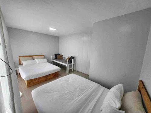 安蒂波洛Monon Antipolo Japanese Onsen Feels的一间小卧室,配有两张床和椅子