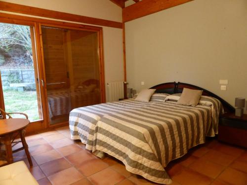 PobesUna casa con vistas en Pobes的一间卧室设有一张床和一个大窗户