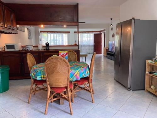 LabattoirL’escale petite terre的厨房配有桌椅和冰箱。
