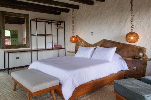 亚美尼亚El Edén Country hotel y Club Residencial的一间卧室配有一张大床和木制床头板