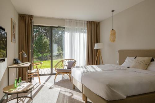 韦巴Hotel Saltic Resort & Spa Łeba的酒店客房设有一张床和一个大窗户