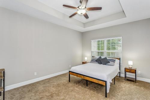 彭萨科拉Lovely Town-home in Pensacola的一间卧室配有一张床和吊扇