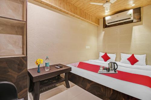 卡延OYO K K Royal Residency的酒店客房配有一张床铺和一张桌子。