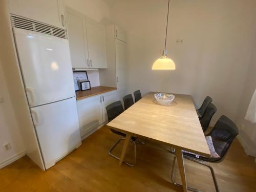 斯德哥尔摩Home Inn KHT15的厨房配有木桌和白色冰箱。