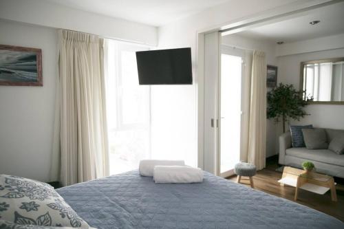 利马Barranco Best Location - Apartment的一间卧室配有一张床、一张沙发和一台电视