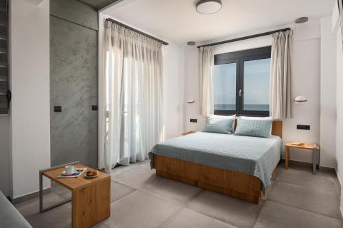 萨尔蒂Vrahakia beach的一间卧室设有一张床和一个大窗户