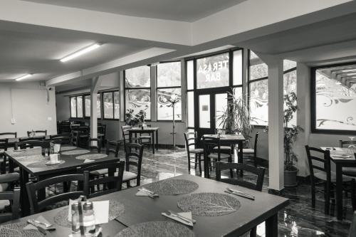 红湖Vila Bradul的用餐室设有桌椅和窗户。