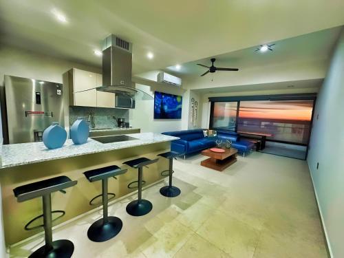 马萨特兰Altomare Seaview的厨房以及带蓝色沙发的客厅。