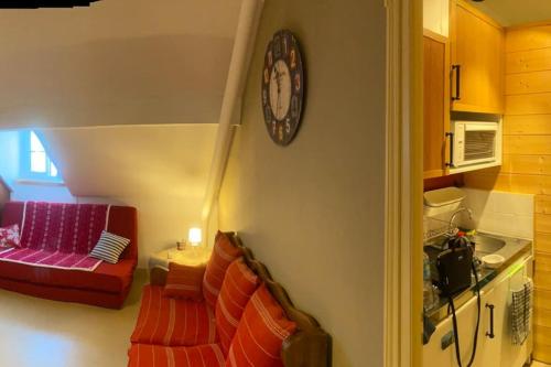 Pugny-ChatenodLocation montagne le Revard的客厅配有沙发和墙上的时钟