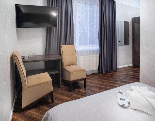 文尼察Safari-Club的酒店客房,配有一张床、一张桌子和椅子