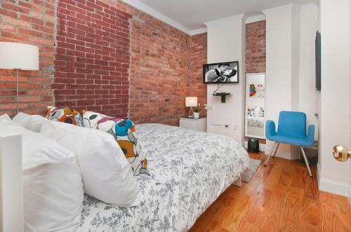 纽约Modern 3BR Apartment in NYC的一间卧室设有一张床和砖墙