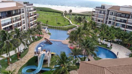 阿奎拉兹Beach Living, Frente mar, 400m do B Park com Restaurante e Toboagua的享有带水滑梯的度假游泳池的空中景致
