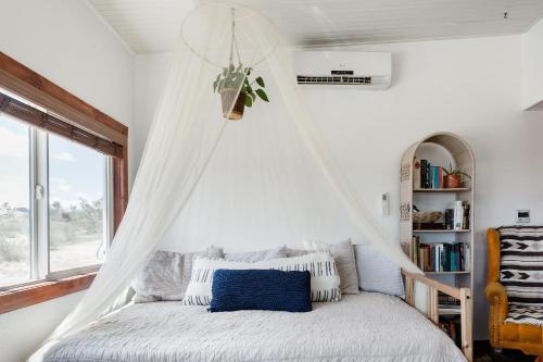 丝兰谷Desert Home Private Oasis Outdoor Space & Hot Tub的一间卧室配有一张带蚊帐的床