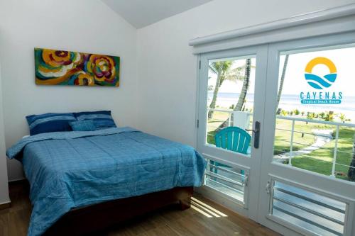 Beachfront Vacation Villa的一间卧室设有一张床和一个滑动玻璃门
