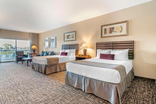 奥克兰贝斯维斯特湾畔酒店的酒店客房设有两张床和一个阳台。