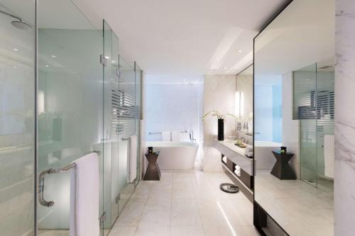 雅加达雅加达希尔顿逸林酒店 - 迪本尼格罗的一间带玻璃淋浴和浴缸的浴室
