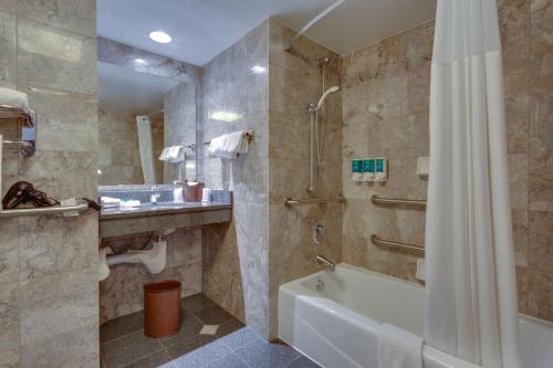 欧弗兰帕克欧弗兰帕克德鲁里套房酒店 的浴室配有浴缸和淋浴及浴帘