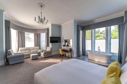 威布里治欧特兰德公园酒店的酒店客房配有床、浴缸和沙发。