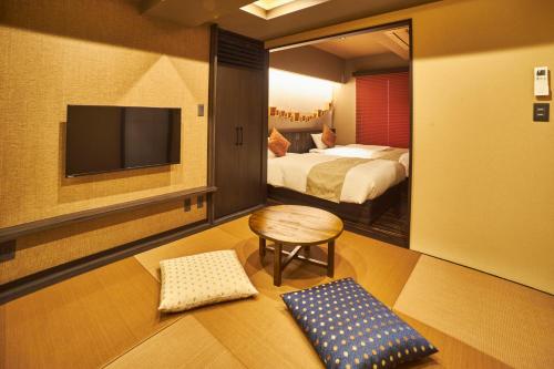 东京SAKE Bar Hotel Asakusa的酒店客房设有两张床和一台平面电视。