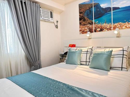 马尼拉CELANDINE Residence by DMCI的一间卧室配有一张带蓝色和白色枕头的床