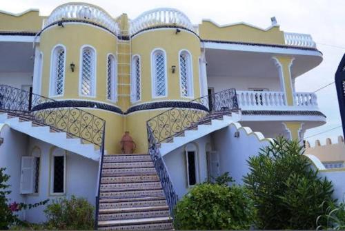 塔格梅斯Laguna的黄色和白色的大房子,设有楼梯