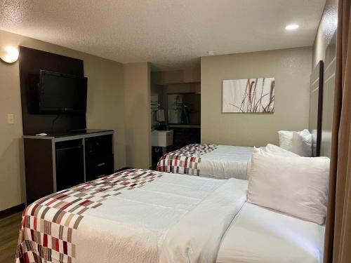 里奇兰Red Roof Inn & Suites Richland的酒店客房设有两张床和一台平面电视。