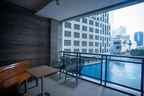 马尼拉Penthouse at Poblacion - 200Mbs net - Awesome view的一个带桌椅的阳台和一个游泳池