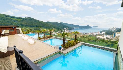 巨济Friemily Pool Villa & Hotel的享有泳池和水景的阳台