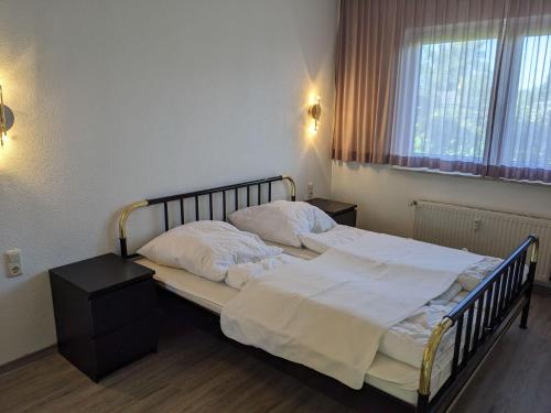奥斯赛拜-屈隆斯博恩Ferienanlage-Reriker-Strasse-EG-rechts-119的一间卧室配有带白色床单和枕头的床。