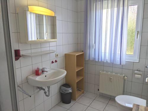 奥斯赛拜-屈隆斯博恩Ferienanlage-Reriker-Strasse-EG-rechts-119的白色的浴室设有水槽和镜子