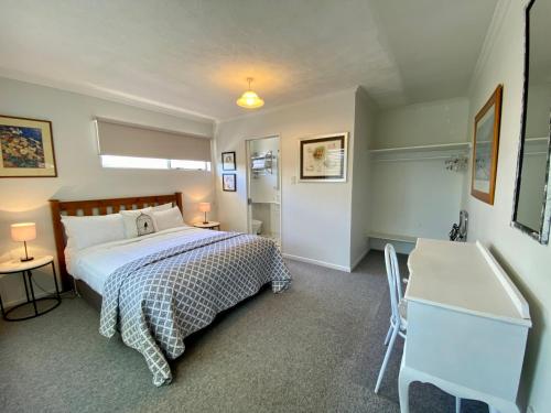 特威泽尔拉斯林度假屋的一间卧室配有一张床、一张桌子和一个水槽