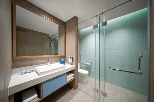 后川IXORA Ho Tram By Fusion的一间带水槽和玻璃淋浴的浴室