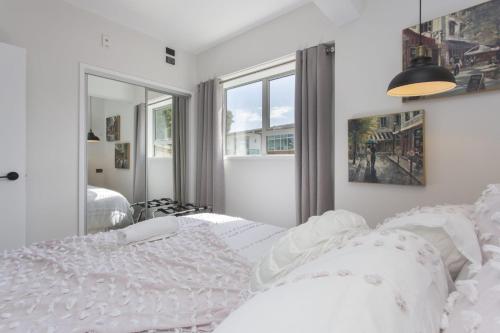 新普利茅斯Chic IN THE City的白色的卧室设有床和窗户