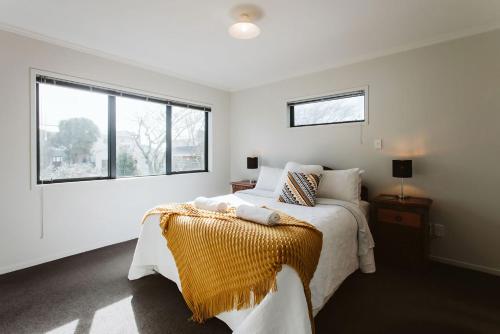 新普利茅斯Seven By The Sea Tourist Hot Spot的白色的卧室设有床和窗户