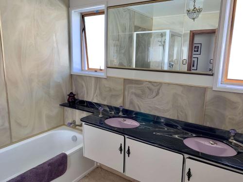 新普利茅斯Blast On Hine的浴室配有两个盥洗盆和浴缸。