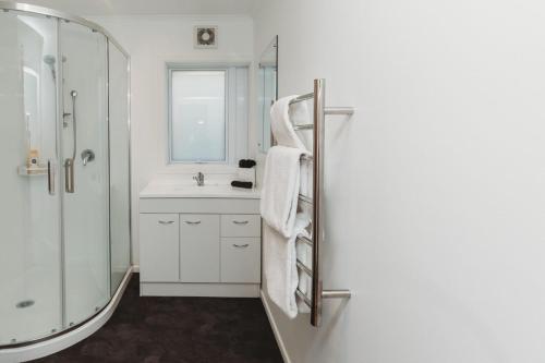 新普利茅斯Wow On Wanaka Bay的带淋浴和盥洗盆的白色浴室