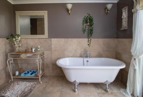 Sentry HillThe Homestead Rural Family Retreat的浴室配有白色浴缸和镜子